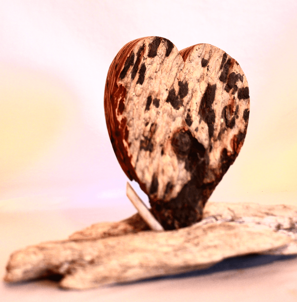 Heart-shaped wooden sculpture on a stone base.