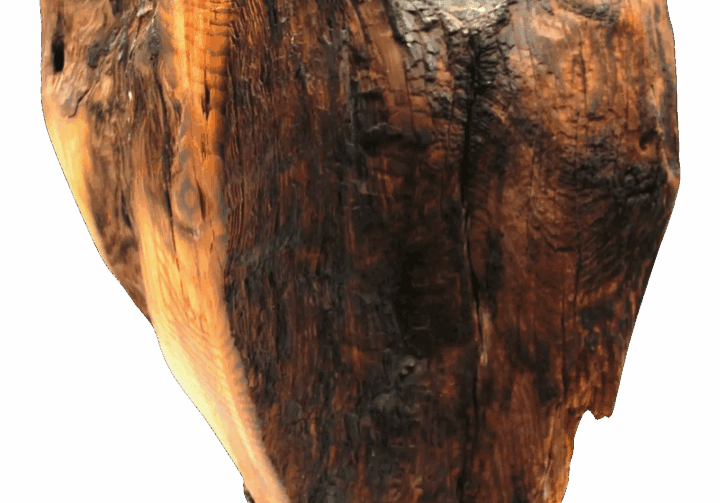 Heart-shaped wooden sculpture on black background.